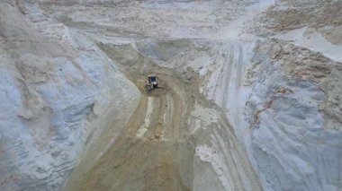 Buldozerin kum ocağında sürüşünün insansız hava aracı çekimi. İnşaat endüstrisi için endüstriyel kum çıkarma. İnşaat malzemeleri. Makine, ekipman, araç, jeoloji