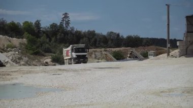 Taş ocağına çakıllı bir çöp kamyonu geliyor. Madencilik endüstrisi, ulaşım. Taş ocağının insansız hava aracı görüntüleri. Ağır ekipman. Açık havada, gündüz vakti