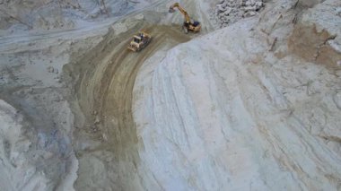 Crawler Exavator ve Buldozer 'in taş ocağında çalıştığı İHA görüntüleri. Endüstriyel manzaranın görüntüleri. Açık çukur. Kum. Madencilik endüstrisi. Kazıcı, makine, açık hava. Hava görünümü