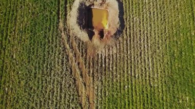 İHA görüntüsü ekili yeşil alan. Maddeyle dolu bir çukur görüntüsü, yanan ateş. Şablon. Açık havada. Şehir dışında, köy dışında. Benzin üretimi. Keşif, tesis, sondaj