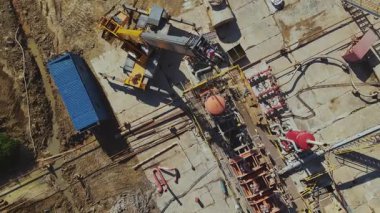 Üretim tesisindeki vinç operasyonunun üst görüntüsü. Metal çerçeveler, sanayi ve ev binaları, ekipmanlar. Yaz zamanı. Açık havada. Gaz üretim şirketi. Pompa ve ekipman. Şehir dışında.