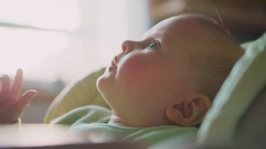 Harika suratlı, yüksek sandalyede oturan, yüzü yemek lekeli bir çocuk. Çocukluk. Kahvaltıda. Yavaş çekim