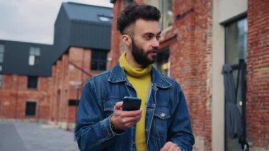 İyi görünümlü bir hippi sokakta yürürken navigatör kullanıyor, bilinmeyen şehirdeki binaların sayısına bakıyor. Sıradan giysiler içinde gülümseyen bir turist. Yoldan geçenlerle konuşuyor, akıllı telefon tutuyor. Açık havada. Sonbahar