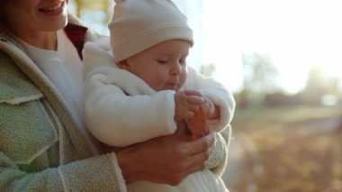 Ellerinde yaprak tutan ve doğayı keşfeden şirin bir çocuğun görüntüsü. Sonbahar parkında anne ve bebeğin portresi. Mutluluk. Çocukluk konsepti. İlgi ve sevgi
