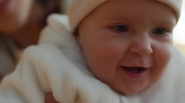 Sarı yaprak tutan komik kızın yakın plan portresi. Güneşli bir günde, annesi çocuğu kollarına alıp sonbahar parkının arka planını bulanıklaştırıyor. Dışarı çıkın. Hafta sonu. Annelik kavramı. Aile