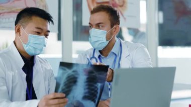 Muhtelif tıp doktorları özel ofiste koruyucu maskeler takarak Coronavirus hastalığı enfeksiyonu akciğer gribi tedavisini tartışıyor. Hastane personeli.