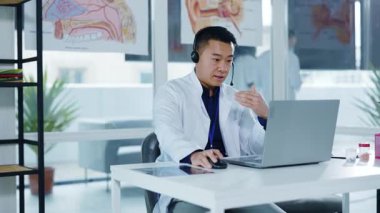 Çinli profesyonel doktor, hastaya danışmanlık yapıyor. İnternetteki bilgisayarlı video konferans, tıbbi sağlık merkezinde. Uzaktan danışma.
