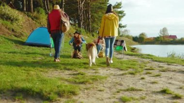 Çekici hippi arkadaşlar doğada parti veriyorlar. Dört genç, köpekle gülümseyen birine sarılır. Tatil turizmi macerası. Yavaş çekim