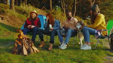 Doğada kamp ateşinin yanında oturan hippi arkadaşları. Gençler oyunlar hakkında konuşurlar, köpeklerin gülümsemesiyle mutlu olurlar. Tatil turizmi macerası. Yavaş çekim