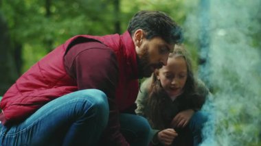 Mutlu baba ve kızı ormanda kamp ateşi çubukları kuruyor. Gülümsüyor. Aile zamanı. Orman mutluluğu doğa yangını. Kapatın. Yavaş çekim