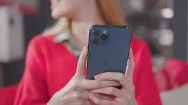 Cep telefonu kullanan genç bir kadın. İletişim, internet teknolojisi dokunuşu. Evde akıllı telefon yazıyorsun. Sosyal medya. Yavaş çekim