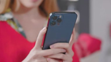 Genç elli kadın cep telefonu kullanıyor. İletişim, internet teknolojisi dokunuşu. Evde akıllı telefon yazıyorsun. Sosyal medya. Yavaş çekim