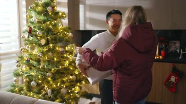 Çekici çok ırklı arkadaşlar, ailelerine sarılmak ve kış tatilinin tadını çıkarmak için evlerine gelirler. Mutlu ol. Noel ağacı. Kutlama selamı. Yavaş çekim