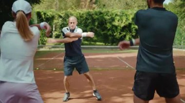 Çekici oyuncular tenis maçından önce antrenörle atlamaya hazırlanıyor. Antrenman antrenmanı başarısı. Spor salonunun erkek sporcusu.