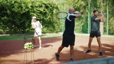 NEW YORK - 5 Nisan 2020: Antrenör tenis oynamayı öğretiyor erkek ve kadın sporcu aktivitesi maç sporcu giyimi antrenmanı ve ağır çekim yaz tepki eğitmeni