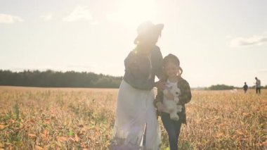 Cute girl with mother walking speaking in field feel happy smiling rural countryside nature. Trip, vacations, parents, landscape, learning. Slow motion