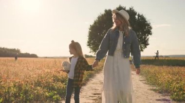 Lovely girl with mother walking speaking in field feel happy smiling rural countryside nature. Trip, vacations, parents, landscape, learning. Slow motion