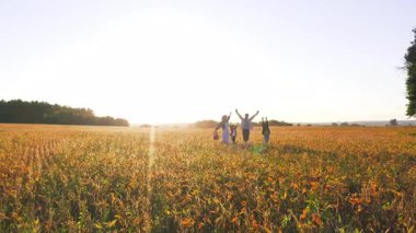 Kırsal kesimde. Mutlu bir aile. Aileleri tarlada yürüyen güneşli gökyüzünün ve sıcak havanın tadını çıkaran iki sevimli çocuk. Birliktelik, duygular.