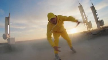 Yetenekli genç stil hip hop bboy dansçısı çatıda serbest stil sokak koreografisi hareketleri yapıyor. FPV konsepti. Geniş açılı kamera.