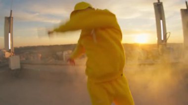 Kapanış dansçısı serbest dans eden sokak dansı koreografisi hareketleri ve geniş açılı kamerada oynaması. Birinci şahıs görüşü. Gün batımı performansı. Çatı.