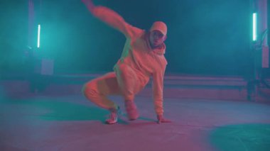 Yetenekli dansçı, gece neon partisinde hip hop yapıyor. B-boy stil adam break dans yapıyor çatıda dans ediyor.
