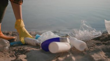 Ekolojik gönüllüler. - Aile. Genç oğlu olan sakallı bir çift yetişkin baba plastik artıklardan kirli göleti temizliyor. Çok saçma. İsraf oldu. Geri dönüşüm.