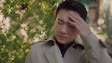 Endişeli Asyalı genç iş adamı, stresli bir şekilde sigara içiyor ve sorunlar yüzünden hayal kırıklığına uğruyor. İş başarısızlığı. Kayıplar. Üzüntü. Bağımlılık. Kötü alışkanlıklar..