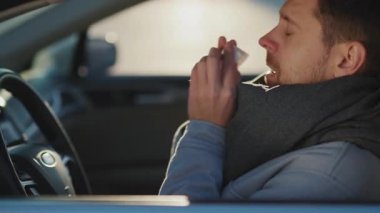 Kafkasyalı hasta, genç bir işadamı arabada oturuyor. Hapşırık alerjisi var. Virüs belirtileri gösteriyor. Coronavirus. Salgın. Sağlık hizmetleri çalışanları.