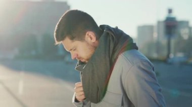 Sokakta yürürken soğuk algınlığına yakalanan Kafkas sakallı genç adam. Grip belirtileri gösteren sağlıksız bir iş adamı. Koronavirüs salgını.