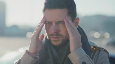 Genç, yorgun, stresli, sakallı, beyaz bir adam tapınaklara masaj yapıyor. Dışarıda korkunç bir baş ağrısı çekiyor. Hastalık. Salgın. Coronavirüs.