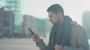 Dışarıda telefon kullanırken hapşıran sakallı genç iş adamı. İnternetten antiviral ilaç alan mutlu, hasta bir adam. E-ticaret. Sağlık Hizmetleri.