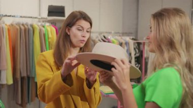 Lüks, modern alışveriş merkezlerinde şık kıyafetler deneyen iki neşeli genç kadın. Arkadaşız. Alışveriş koliği..