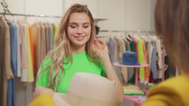 Elbise mağazasında buluşan mutlu bir çift genç bayan arkadaş. İki çekici kadın lüks giysi eşyalar seçiyor. Birlikte deniyorlar..
