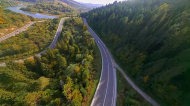 FPV insansız hava aracı muhteşem açık manzara vahşi doğa manzarası orman orman dağları aydınlık bir günde. Manevra kabiliyeti olan bir uçuş. Hava sineması videosu.