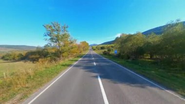 Kırsal vadide manevra yapılabilir uçuş. Tarımsal alanlar arasındaki boş asfalt köy karayolu. Güneş ışığı. Yaz zamanı. Macera. Özgürlük kavramı. FPV.