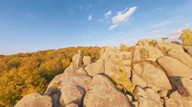 Dovbush Kayaları. Karpat Dağları, Ukrayna. Sonbahar renkli doğa ormanı ağaç tepelerinin FPV uçuş insansız hava aracı manzarası.