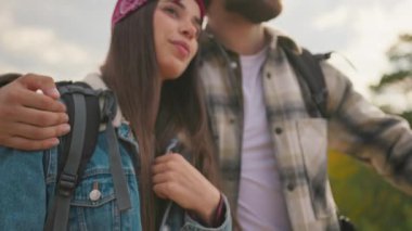 Dağın tepesinden ilham verici manzaranın tadını çıkaran mutlu gezgin çiftin yakın çekimi. Sırt çantalı iki romantik turist. Aile maceraları.