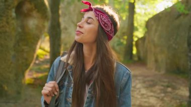 Genç gezgin, çekici beyaz kadın turist sırt çantası takıyor ve yaz yeşil dağ ormanlarında yürüyüş macerasının tadını çıkarıyor. Seyahat kavramı.