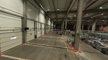 Lojistik parktaki FPV İHA uçuşu. Lojistik Merkezi perakende deposu. Teslimat mallarıyla çalışan personel.
