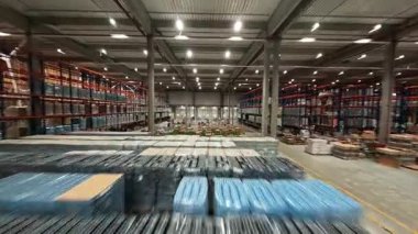 Modern perakende deposunun FPV insansız hava aracı hız görüntüsü. Teslimat kutularıyla birlikte lojistik merkezi ürün dağıtım deposu.