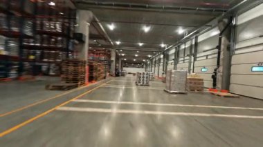 Depoda uçuş. FPV helikopter görüntüsü lojistik merkezinin devasa endüstriyel yapı deposu içinde. Ürün dağıtımı. Teslimat. Lojistik.