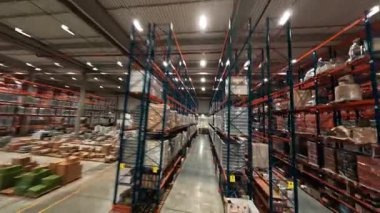 Çağdaş endüstriyel perakende deposunda hızlı FPV insansız hava aracı uçuşu. Teslimat malları ve ulaşımla dolu büyük bir lojistik park. Zaman ayarlı görünüm.