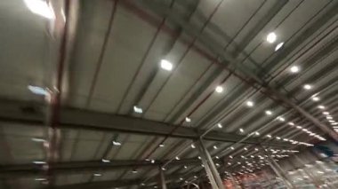 Lojistik merkezi. Hava FPV manevra kabiliyeti olan insansız hava aracı uçuşu rafların üzerinde. Endüstriyel modern perakende deposu. Depolama.