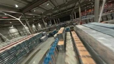 FPV İHA uçağını endüstriyel deponun içinde görüntüleyin. Lojistik parkı. Dağıtım malzemeleriyle dolu büyük bir depo..