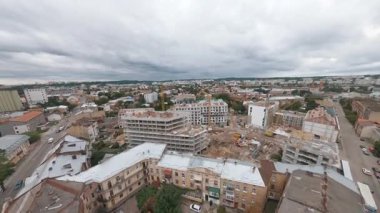 Güzel şehrin üzerinde uçan FPV insansız hava aracı, tarihi caddelerin üzerinde evler, inşaat alanı ve yerleşim yeri olan modern binalarla uçuyor..