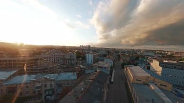 Güzel, modern şehirde FPV uçuşu. Evleri, anıtları ve inşaat binaları olan resimli sokaklar. Gün batımı manzarası. Şehir manzaraları.