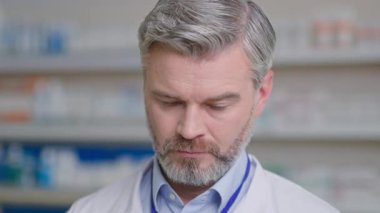 Yakından bakan yakışıklı doktor beyaz tenli yetişkin erkek eczacı danışman kameraya bakıyor. Portre eczacısı. Tıp sektörü. Sağlık Hizmetleri.