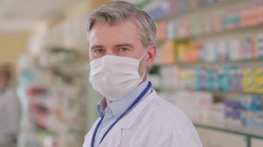 Eczanede maske takan yetişkin bir doktor çalışıyor. Portre eczacısı danışmanı. Emekçi kıyafeti giymiş ve yüz koruması altında. Salgın. Coronavirus. Sağlık hizmetleri kavramı.