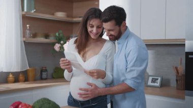 Kafkasyalı mutlu bir çift müstakbel anne ve baba küçük bebeklerinin ultrason fotoğraflarını izliyorlar. Aile hayatı. Uzun bir ilişki. Ebeveynlik.