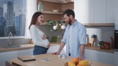 Müstakbel ebeveynler mutfakta iletişim kuruyor. Kocasıyla karnını doyuran hamile, beyaz bir kadın. İlişki. Aileler.